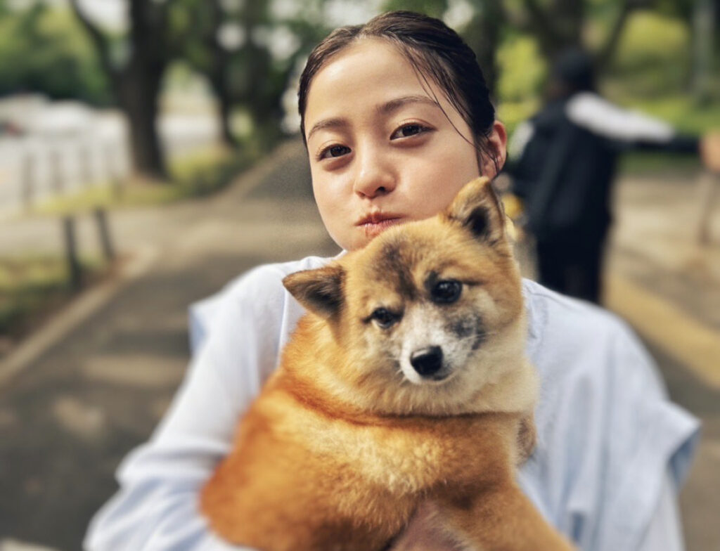 橋本環奈が犬を抱えてこちらを見ている