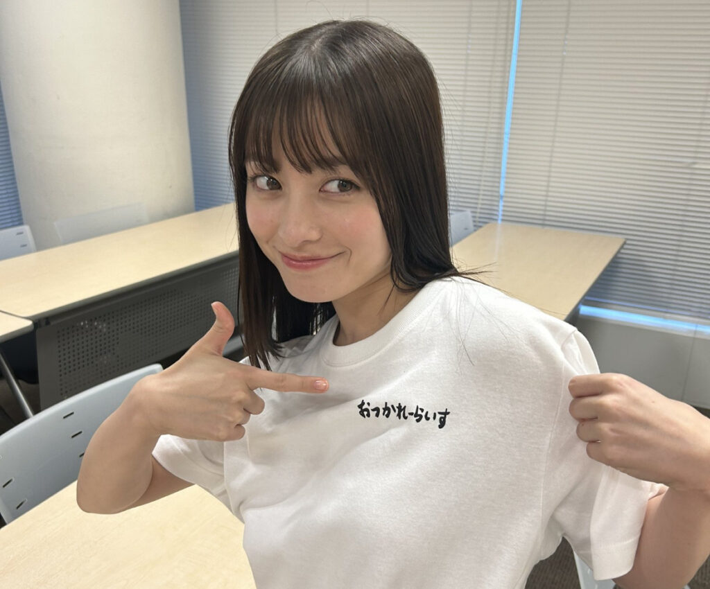 橋本環奈が服を指差して横を見ている