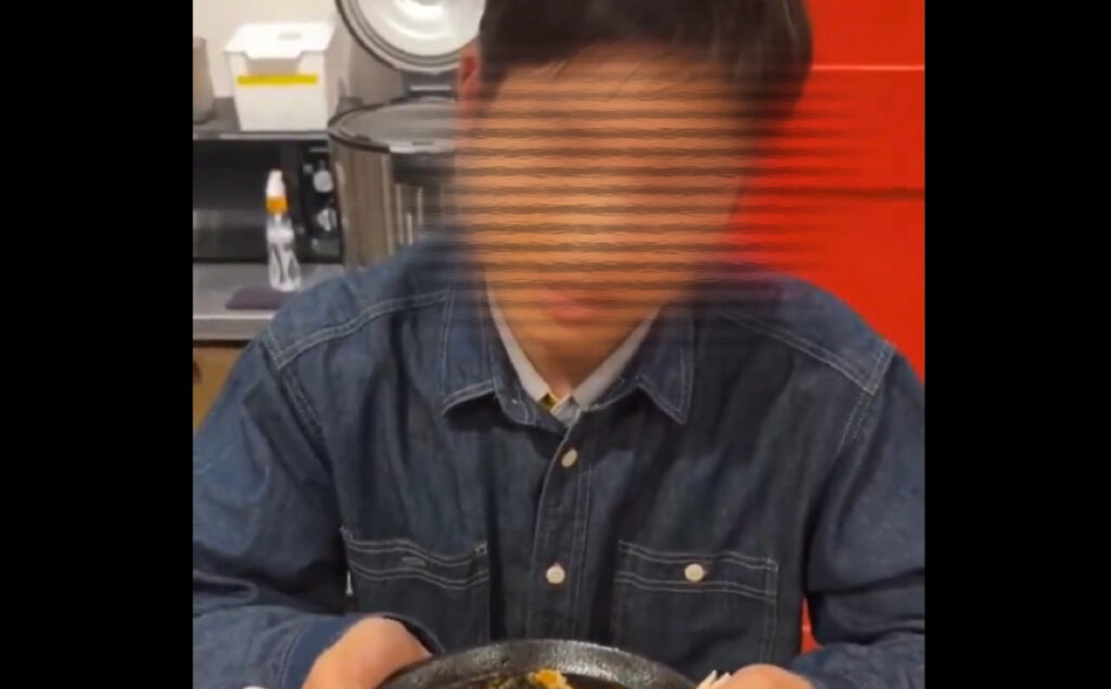 男性がラーメンを持っている